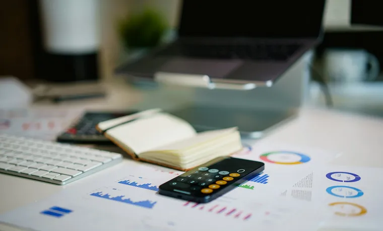 Financial charts and a phone on an office desk